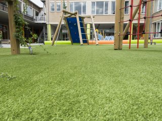image of artificial grass installed on the floor of a children's playground and climbing frame