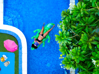artificial grass around a swimming pool and someone swimming