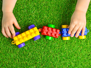 children playing with colourful plastic toys on artificial grass