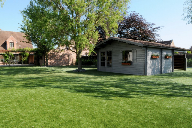 artificial grass installed in the back garden around a country-styled blue garden shed